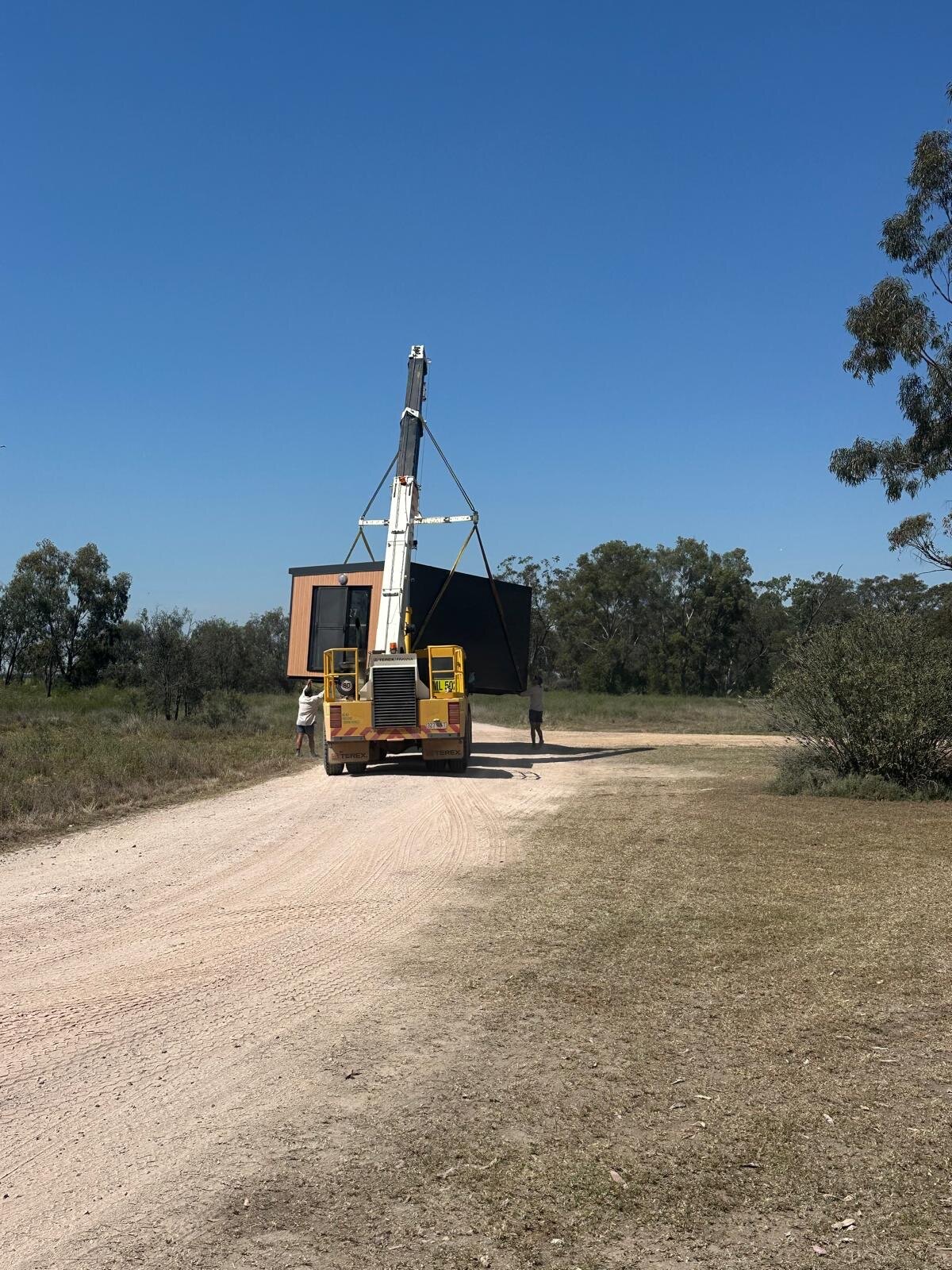 Portable accommodation unit being positioned by crane